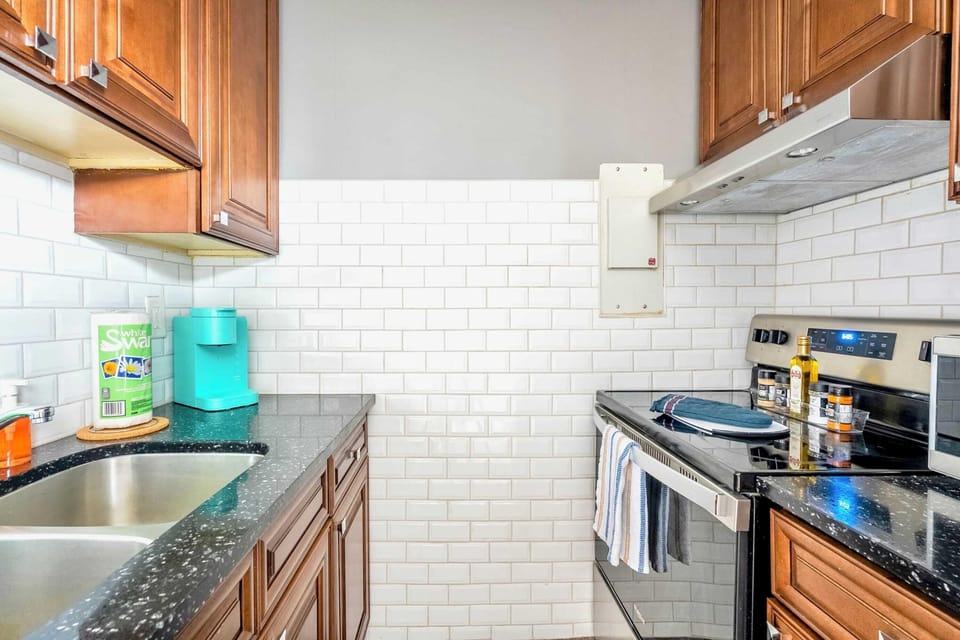 Fully Equipped Kitchen Featuring A Stylish Backsplash And Essential Cooking Amenities