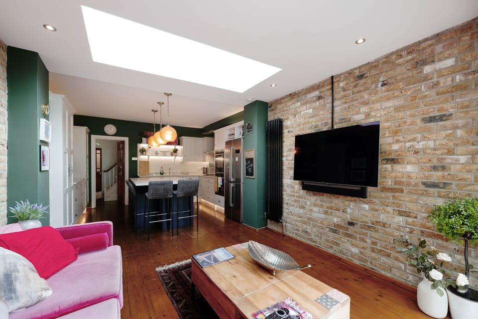 A second living room adjacent to the open-plan kitchen with concertina doors opening to the garden