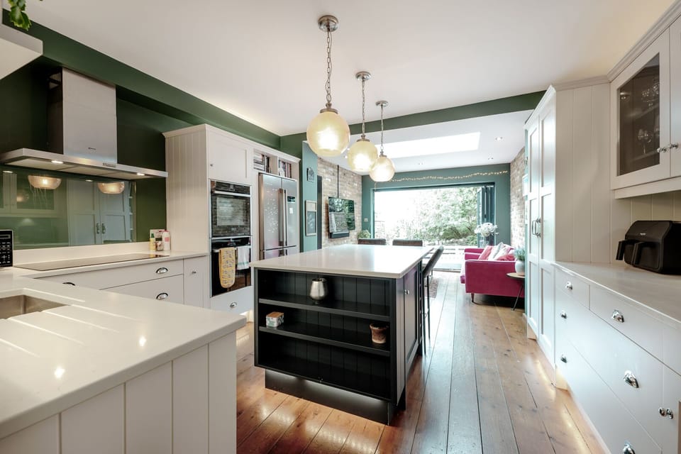 A fully equipped kitchen featuring a coffee machine, air fryer, and spacious island for cooking and socialising