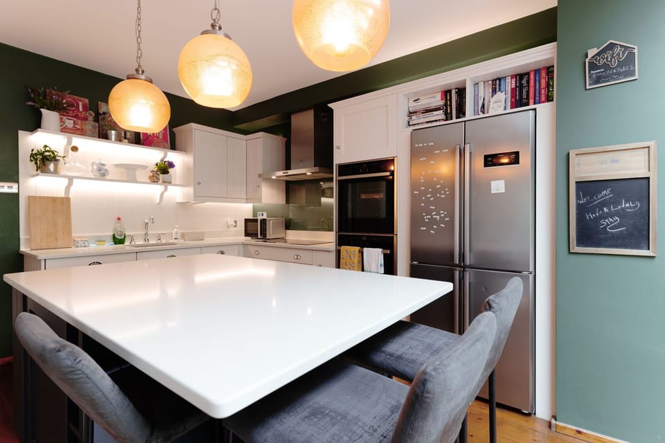 A fully equipped kitchen featuring a coffee machine, air fryer, and spacious island for cooking and socialising