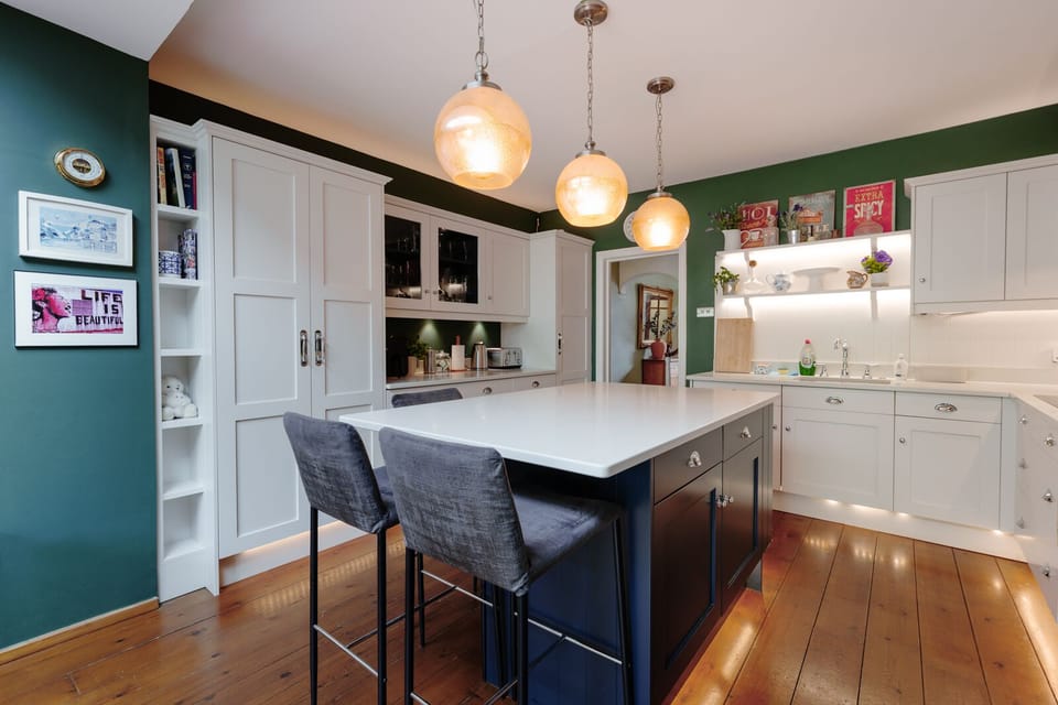A fully equipped kitchen featuring a coffee machine, air fryer, and spacious island for cooking and socialising