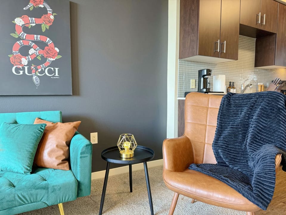 The living area features elegant decor, highlighted by a comfortable accent chair that invites relaxation.