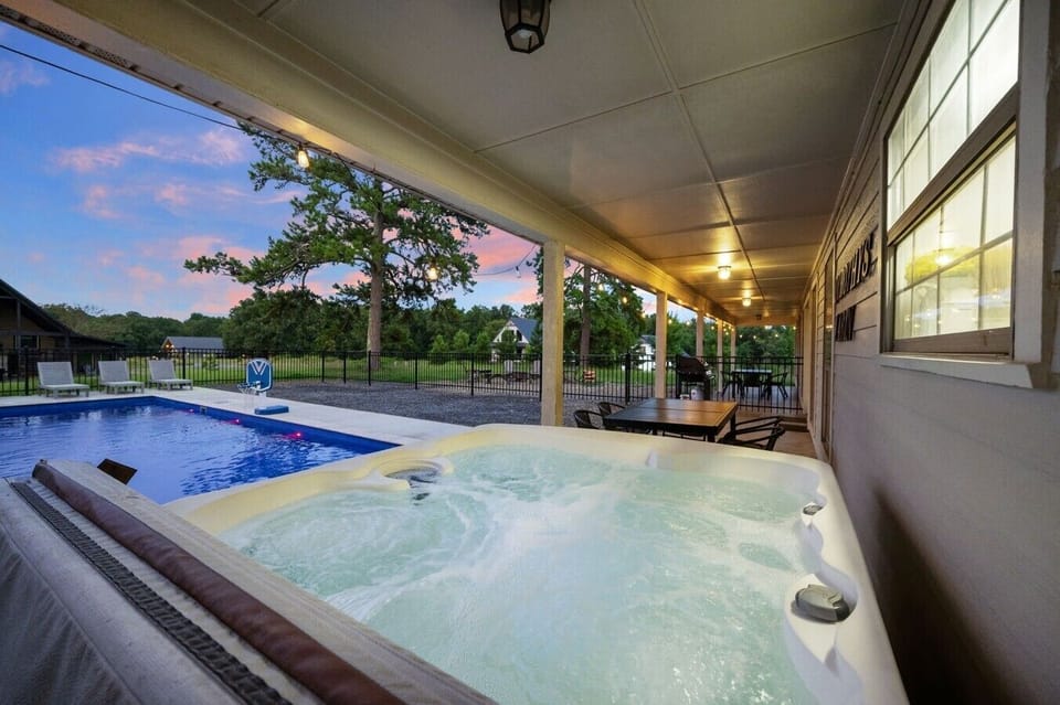 Hot tub and pool connected under the covered outdoor living space.