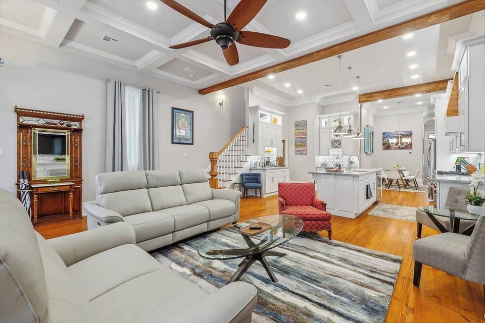 The den/living room provides ample space with 12' coffered ceilings, a 65" smart TV, blackout curtains, and comfortable leather recliners.