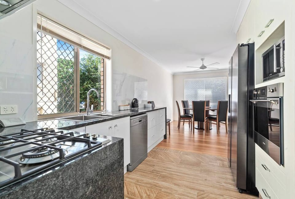 The kitchen has ample storage and contemporary appliances with a large pantry, french-door fridge, oven, dishwasher and microwave. 
