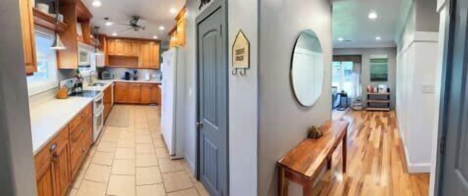 Fully equipped kitchen for preparing meals after exploring Kanab, leading to a bright hallway with beautiful hardwood floors.