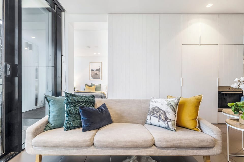 LIVING ROOM: Relax into a plush sofa, draped in a calming, curated palette. Whether watching your favorite show or taking in the stunning Southbank skyline, this will quickly become your perfect retreat.