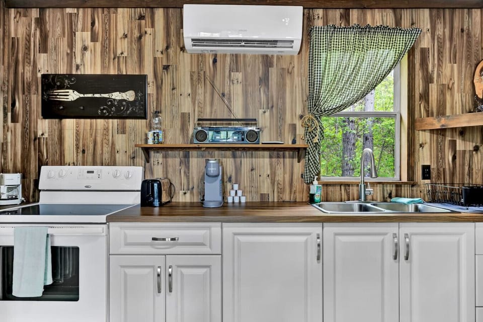 Charming kitchen with rustic wood paneling, modern appliances, and farmhouse touches.