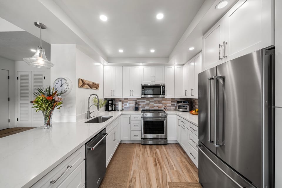 Fully equipped kitchen with sleek appliances, ample counter space, and island seating for effortless meal preparation and gatherings.