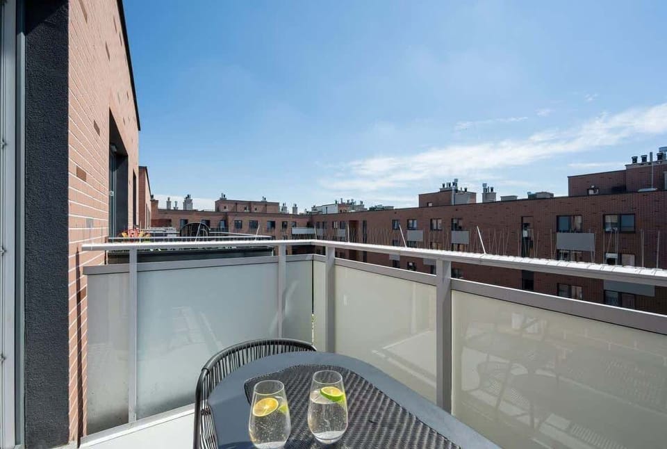 A cozy balcony with a city view and a coffee table is a perfect spot for morning coffee or evening relaxation.