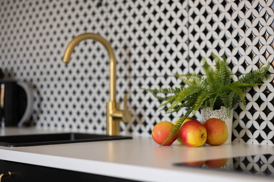 Subtle greenery and warm wood tones soften the kitchen area, giving it a homey charm.

