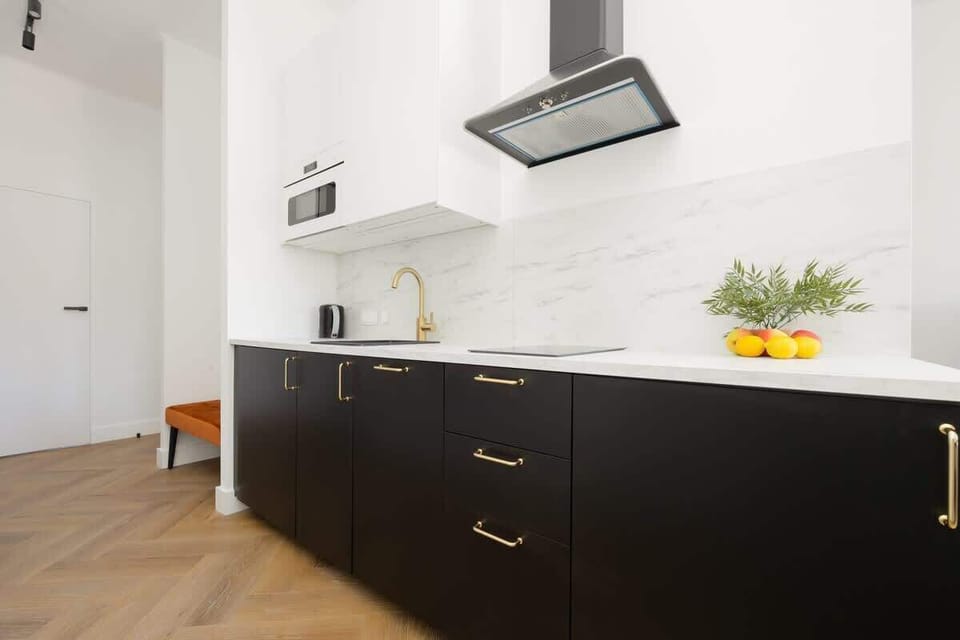 The kitchenette in matte black with wooden countertops combines modern style and functionality, perfect for preparing home-cooked meals.

