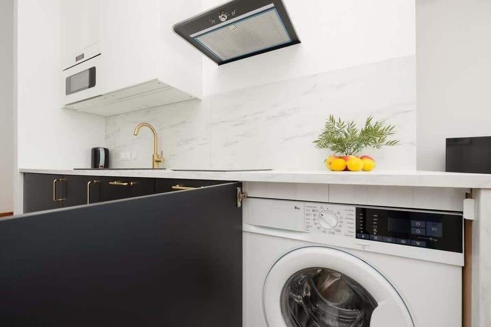 A practical kitchen with a washing machine and modern appliances makes longer stays convenient and easy.

