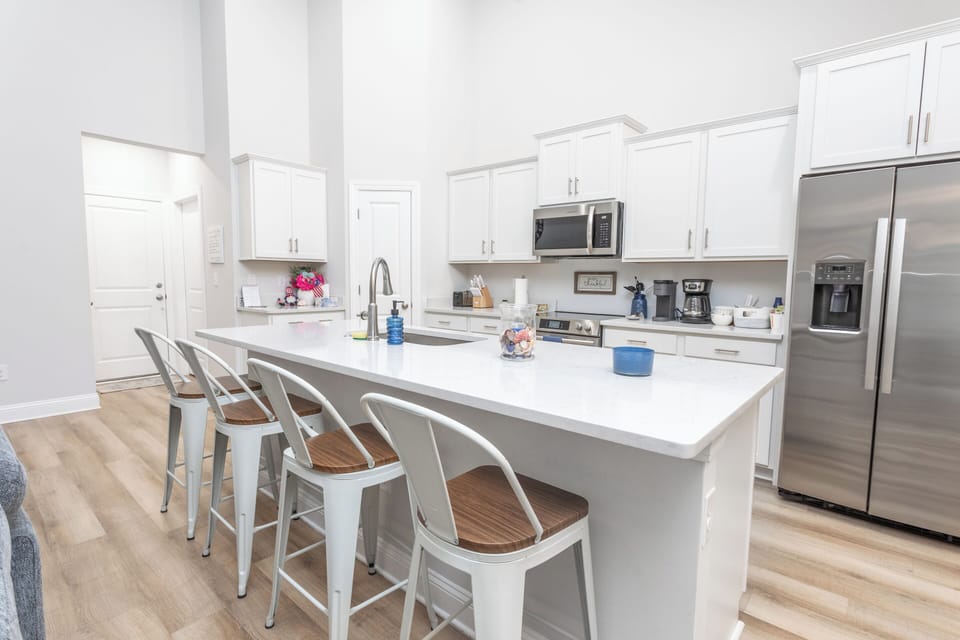 Modern fully equipped kitchen with large island, stainless steel appliances, Keurig & bar seating – perfect for group stays, meal prep & entertaining