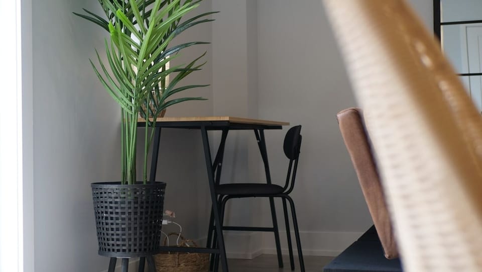 Maximize your productivity with our workspace equipped with a wood-top desk and a houseplant placed in the corner to ensure less distractions.
