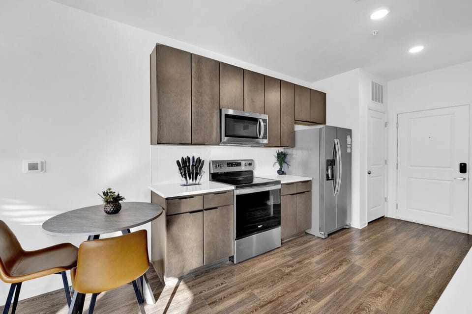 Modern kitchen with a sleek dining area, perfect for cooking, serving, and enjoying meals in style during your short-term rental stay