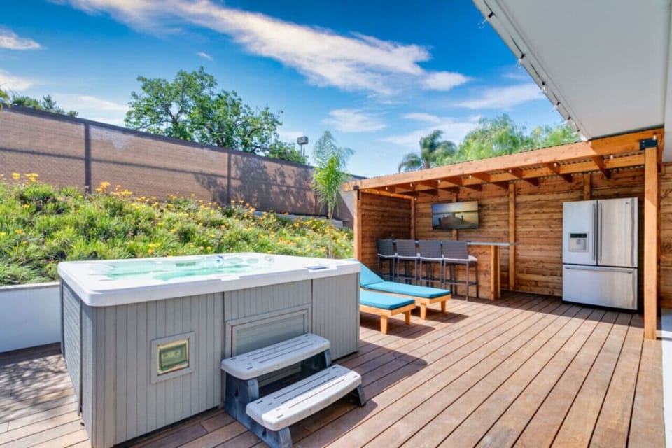 Jacuzzi on a spacious wooden deck, outdoor kitchen and bar