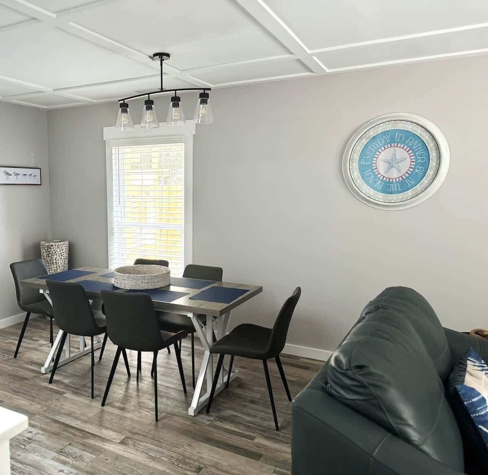 A stylish dining space with a modern wood-top table and six sleek black chairs.