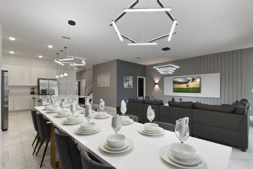Modern open kitchen, dining, and lounge area with sleek finishes and bold lighting
