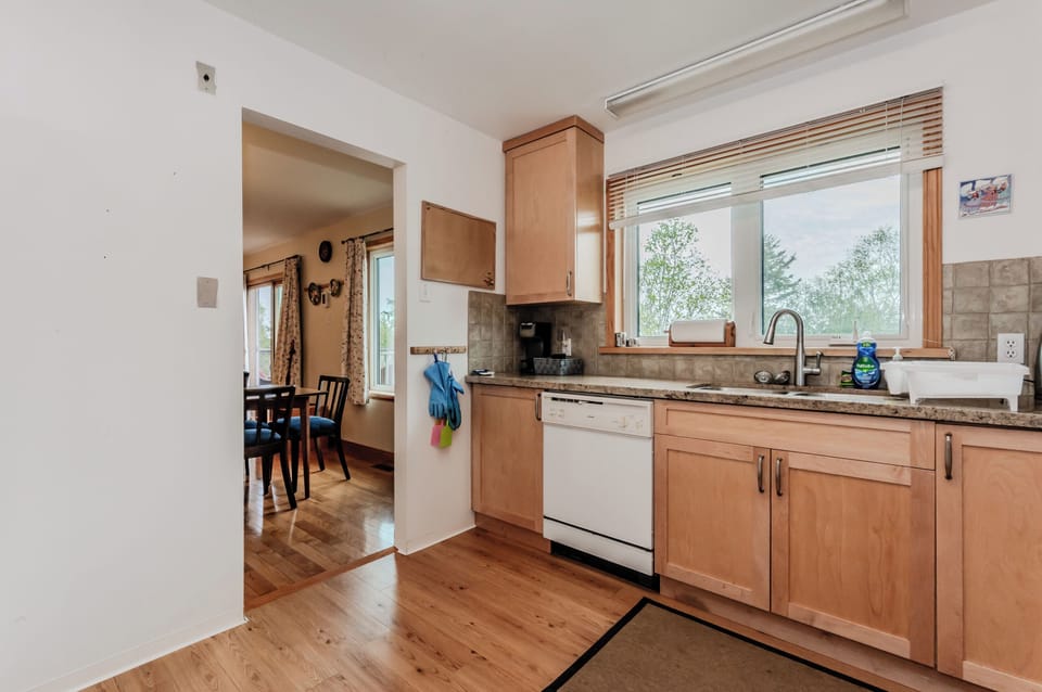 Fully equipped kitchen with natural light and everything you need to prepare meals during your stay. Easy flow into the dining area for convenience.

