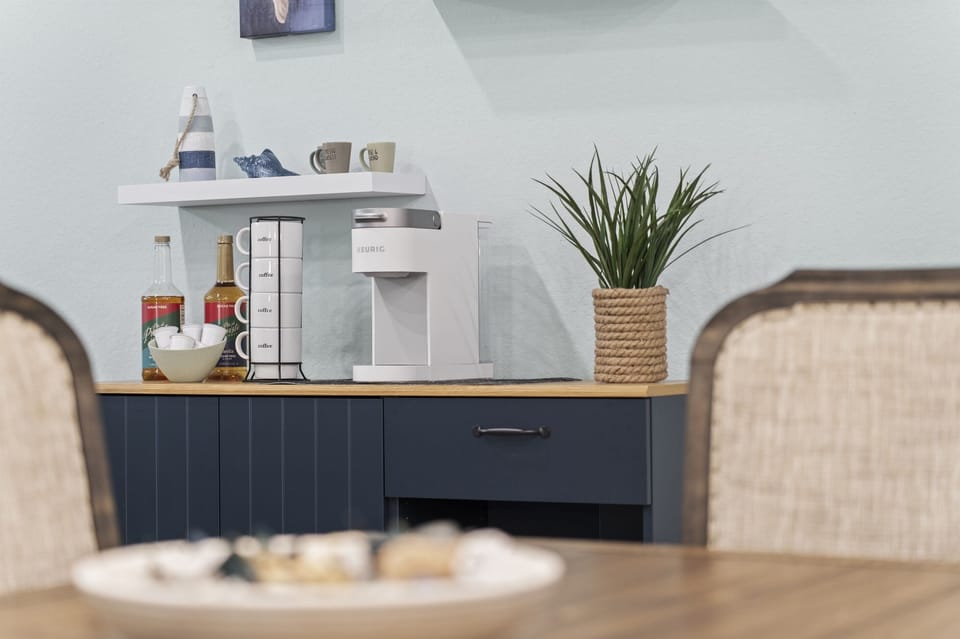 Enjoy a convenient coffee station stocked with mugs, flavors, and all your morning essentials, perfect for starting the day with a warm sip before heading to the beach.