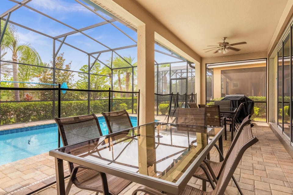 Relax on the spacious screened patio with a pool view, perfect for outdoor dining and lounging.