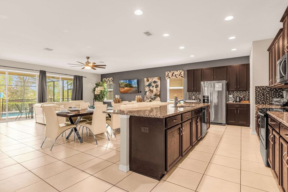 Elegant open-concept kitchen and dining area with pool views, perfect for entertaining and family gatherings.