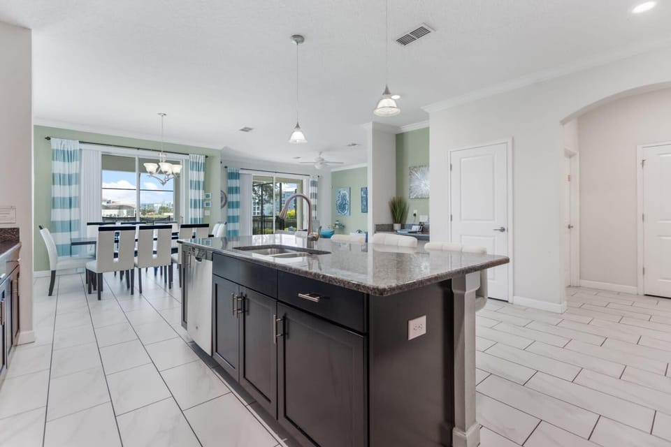 Bright and modern kitchen with a spacious island and dining area, perfect for family gatherings and culinary adventures.