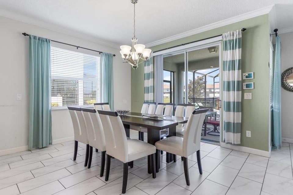 Bright and airy dining room with seating for eight, perfect for family gatherings and overlooking a serene patio.