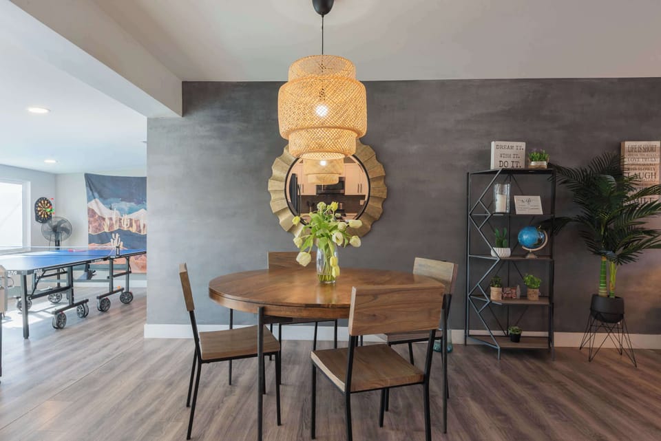 Stylish dining setup w/ statement lighting, perfect for shared meals & easy conversation.