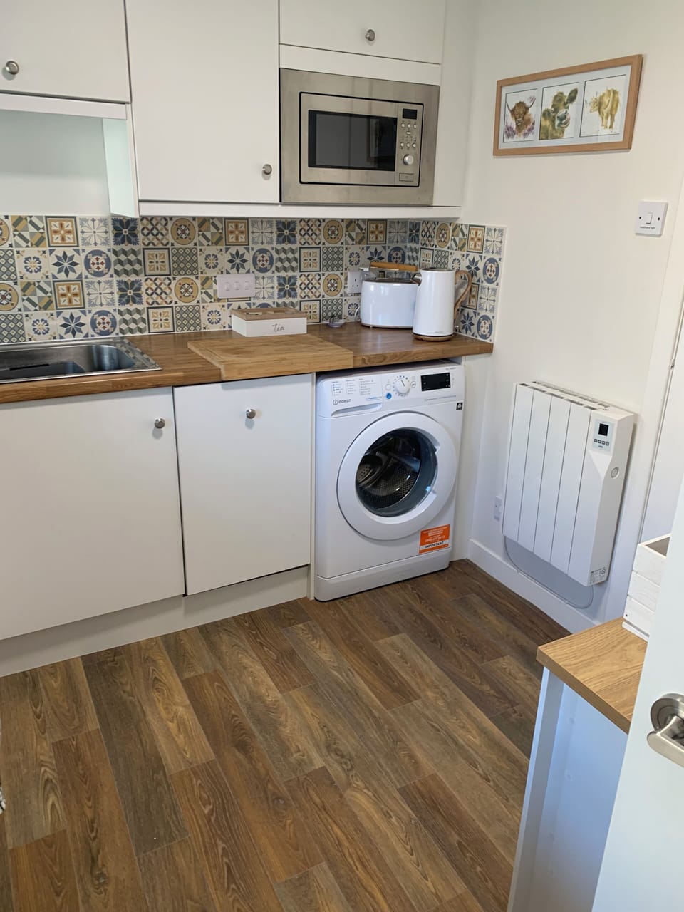 Kitchen with dishwasher, washing machine, microwave