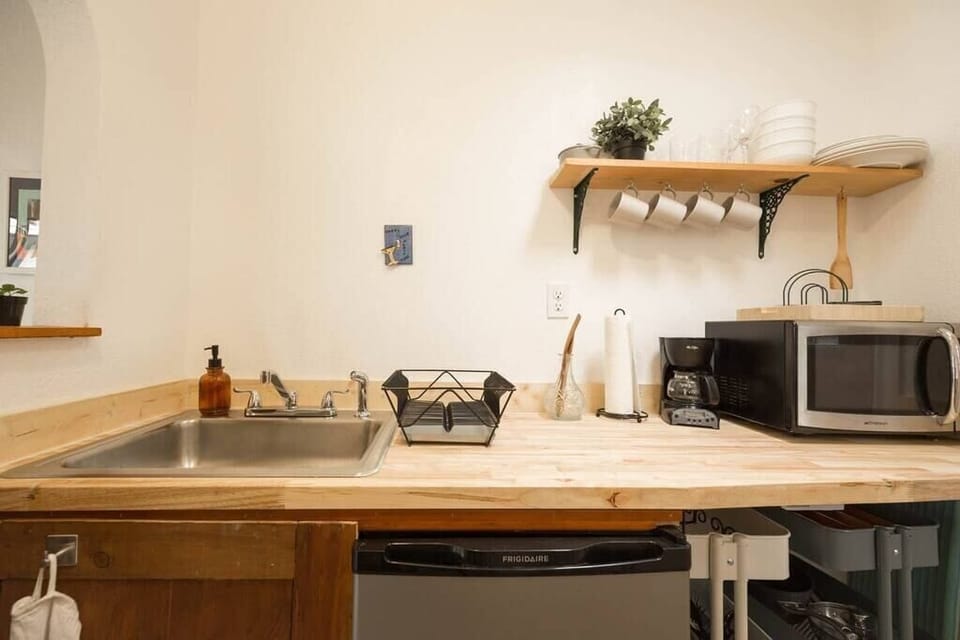 Kitchen comes with: sink, fridge, microwave, coffee maker, one burner, pots, pans, cutting board, utensils and  all the dishes you'll need!