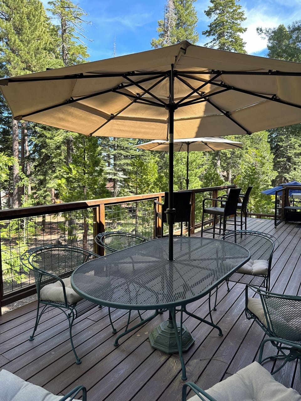 Upper deck off great room with dining table, bar rail seating and grill