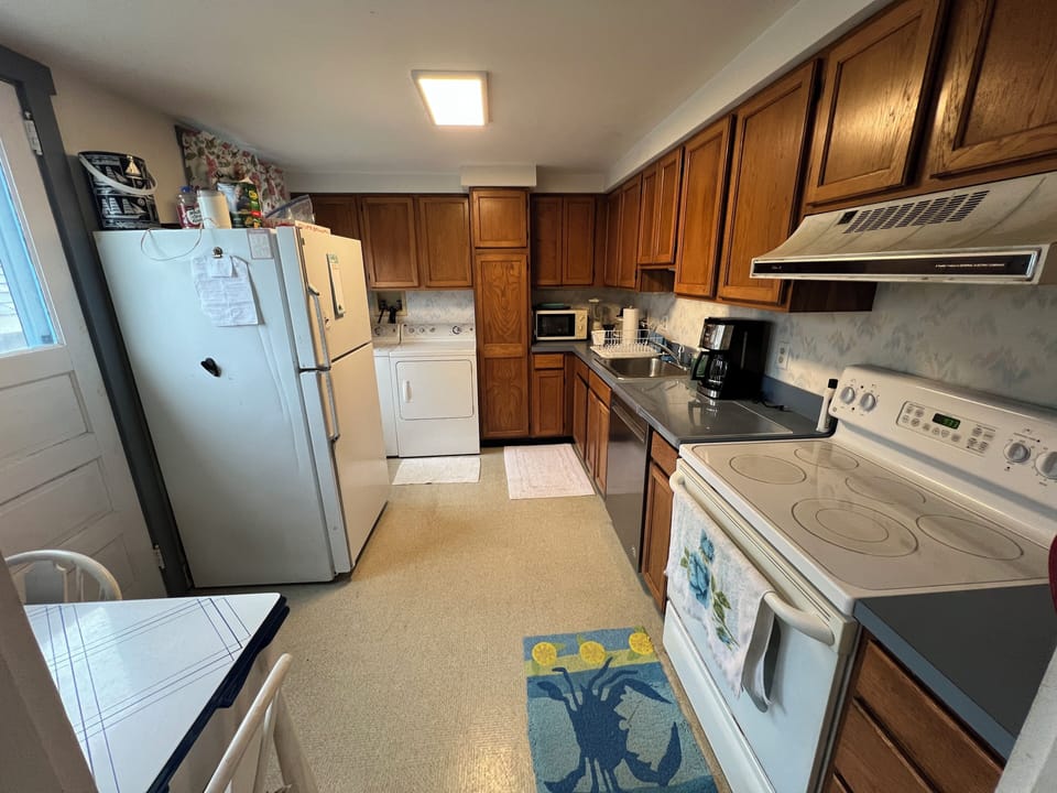 Kitchen seen from DR with stove, dishwasher, washer and dryer.