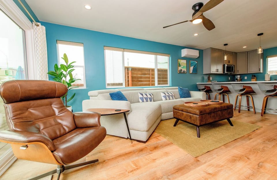 Super comfortable, open space living room features an 8 foot sliding glass door directly to the front deck creating extended room. It's climate controlled with a 75" TV, a fireplace, spacious sofa, and a real leather recliner chair. 