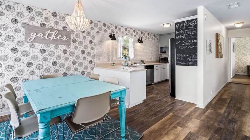 Your open kitchen flows into a bright dining area with turquoise table and charming chandelier.