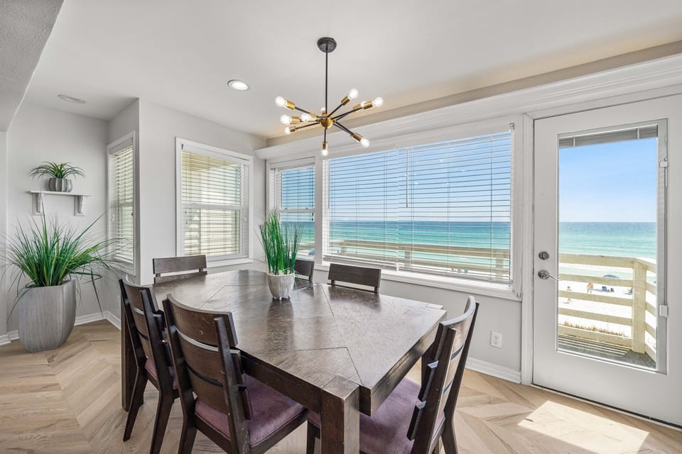 Your beachfront dining room features panoramic ocean views through floor-to-ceiling windows, creating the perfect backdrop for memorable meals with loved ones.