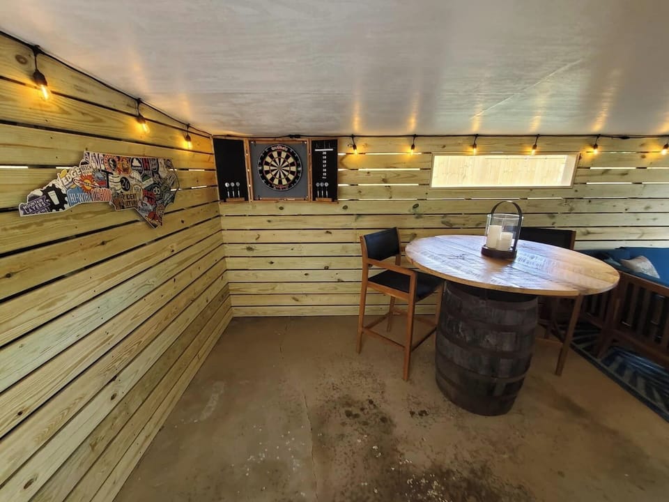 Covered patio with dart board and barrel table.