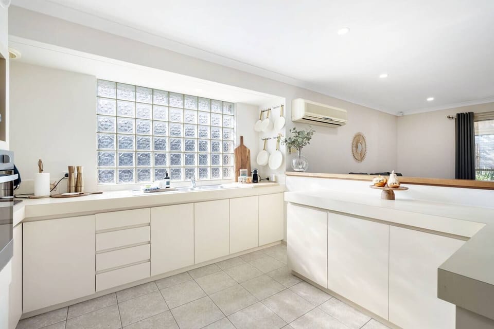 Prepare your favorite meals in this bright and modern kitchen, boasting ample counter space and sleek cabinetry. The unique glass block window provides privacy while letting in plenty of natural light. 