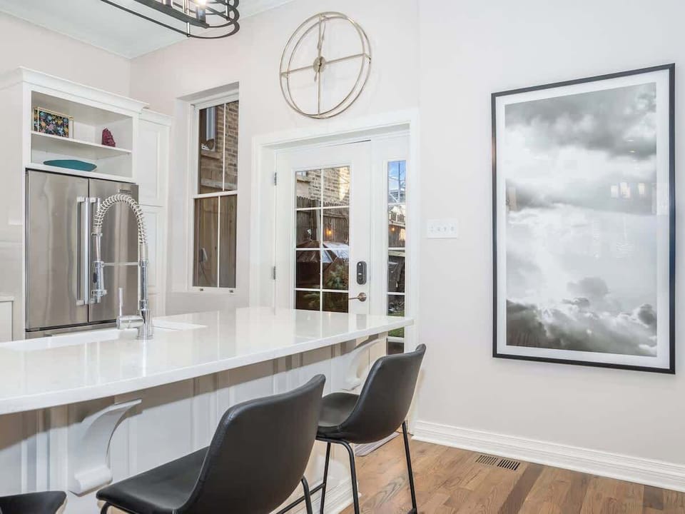 An open glass door leads to the elegant backyard, seamlessly merging indoor and outdoor spaces. Enjoy lush greenery, stylish seating, and serene ambiance, perfect for relaxing or entertaining.