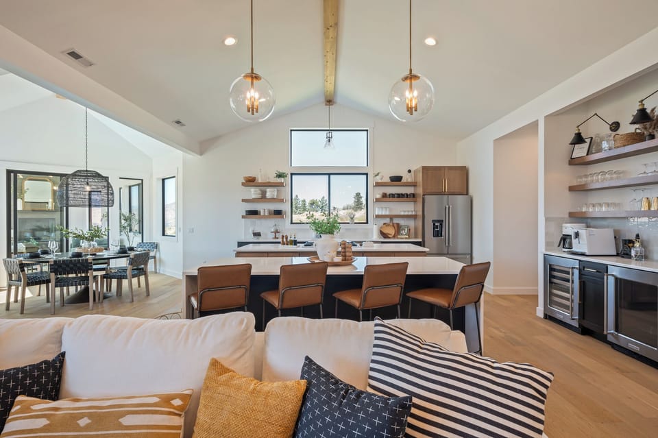 Large, open concept main floor with living room, double island kitchen, dining room and coffee/wine bar