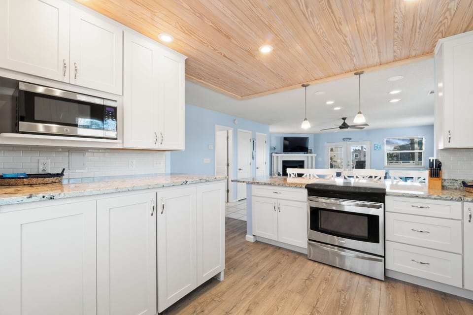 Your fully-equipped gourmet kitchen features granite countertops, stainless steel appliances, and warm wood ceilings for memorable meal preparation.