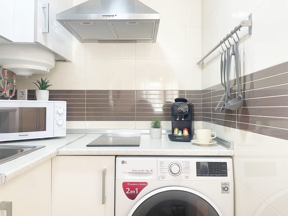 Efficiently configured kitchen in an 'L' shape, maximizing the workspace. Features high-capacity white cabinets and essential integrated appliances for optimal functionality.