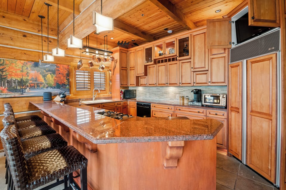 Well-equipped kitchen with a breakfast bar, Smart TV, and coffee machine. 
