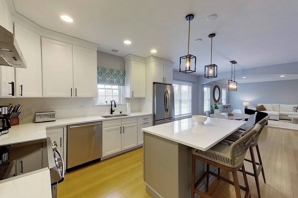 The kitchen has a glass top stove, microwave drawer in the island, dishwasher, french door fridge with lower freezer drawer, decorative pendant lighting and more. 