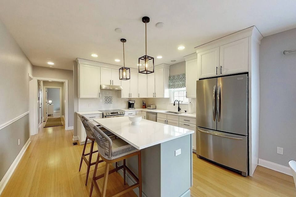 The kitchen has a breakfast bar with two stools