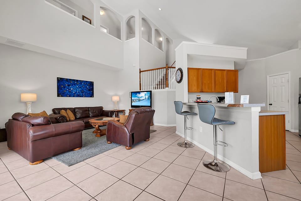 Gather in the spacious living area with comfortable seating, a large flat-screen TV, and an open layout perfect for family time and relaxation.