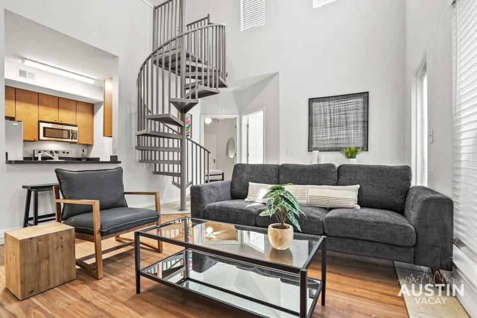 Living room in the first apartment with sofa, smart tv and high ceilings