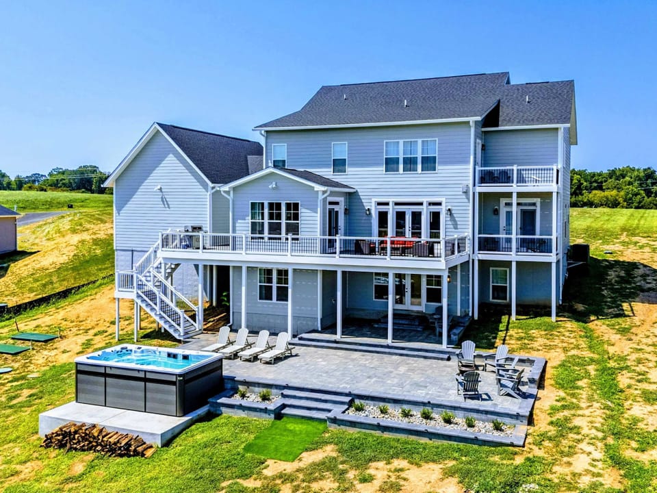 Backyard - Aerial view of the full property, the home and its private lakefront shoreline framed by open water and quiet cove.