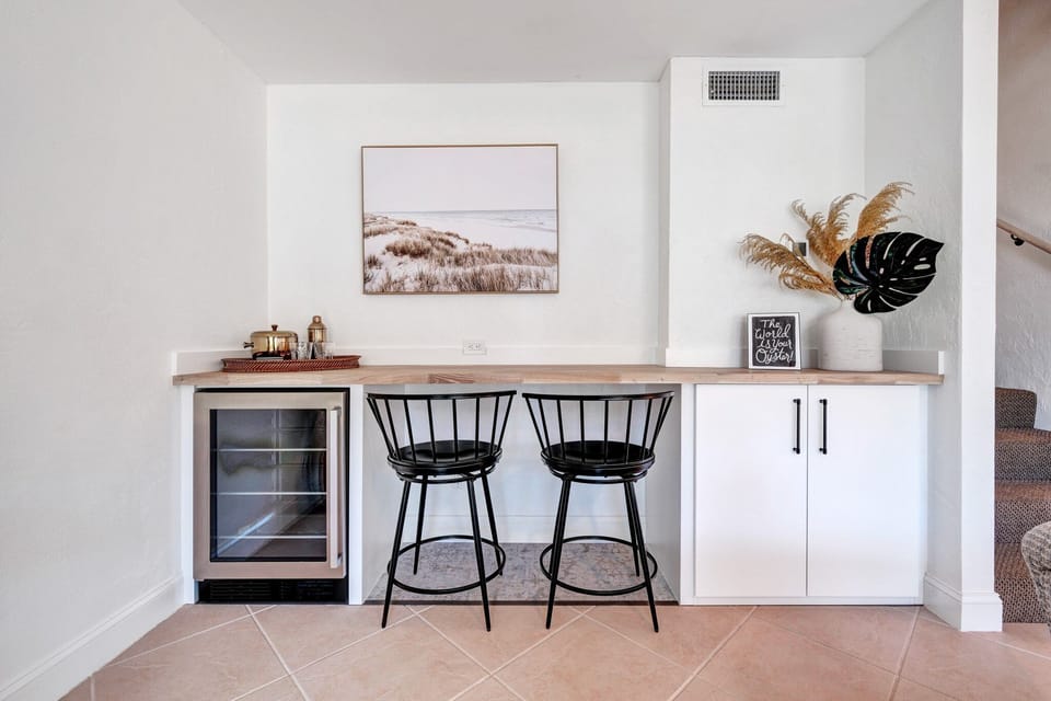Enjoy bonus seating with two barstools and a wine fridge just off the living room - perfect for casual gatherings and unwinding.